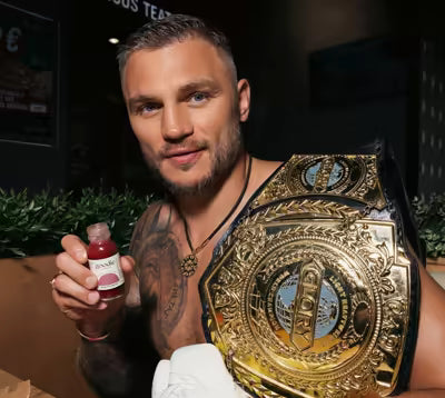 Sergej Maslobojev holding a Goodie bottle and championship belt