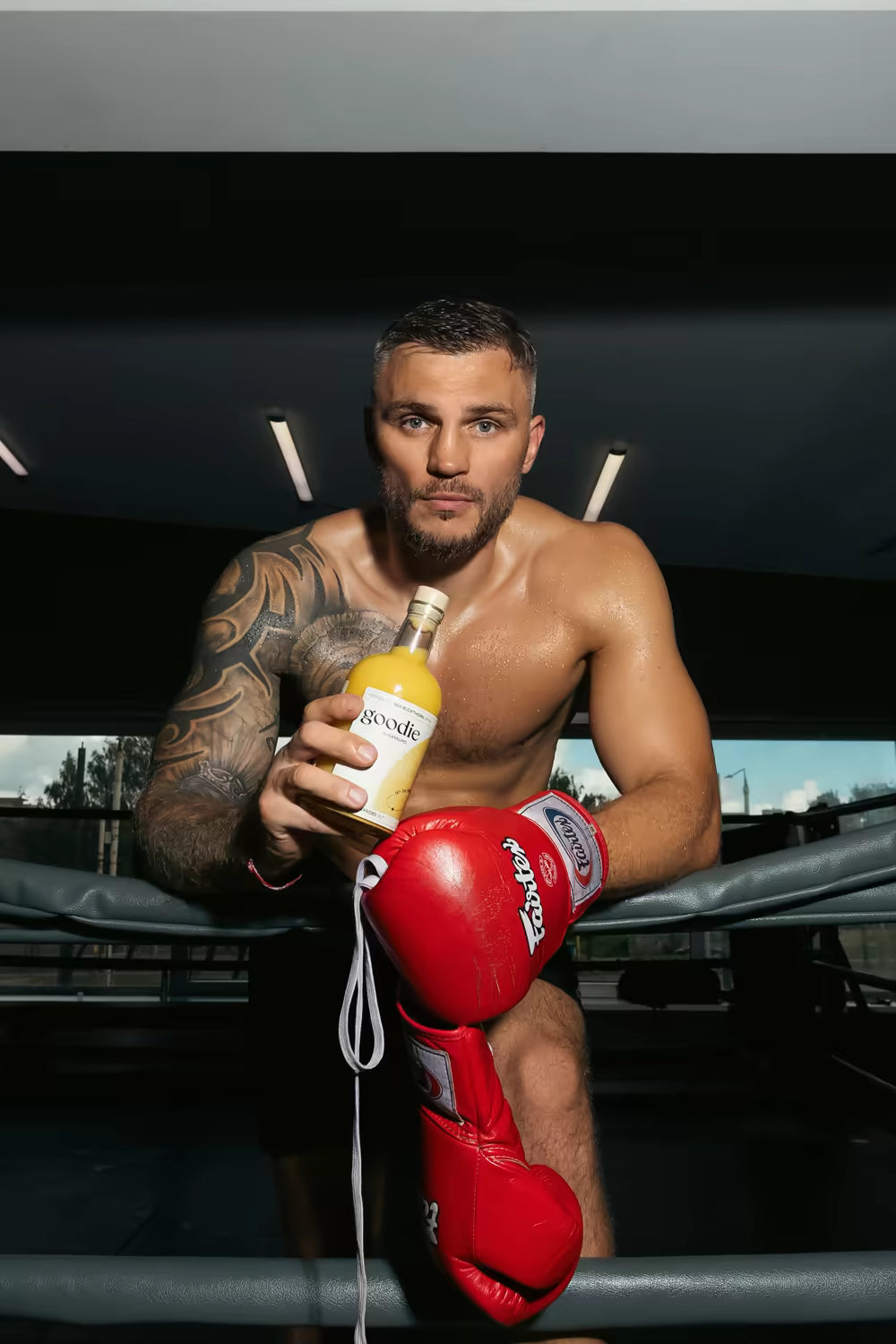 Sergej Maslobojev, World kickboxing champion, holding a bottle of Goodie in a boxing ring